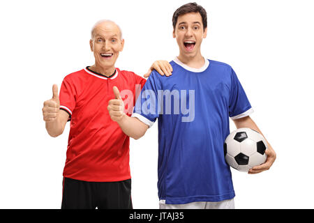 Senior and young man dressed in jerseys holding a football and making thumb up signs isolated on white background Stock Photo