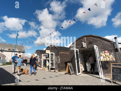 Family walking through Amble harbour Village, Northumberland, England, UK Stock Photo