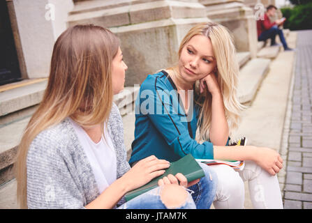 Two female students sitting and talking Stock Photo