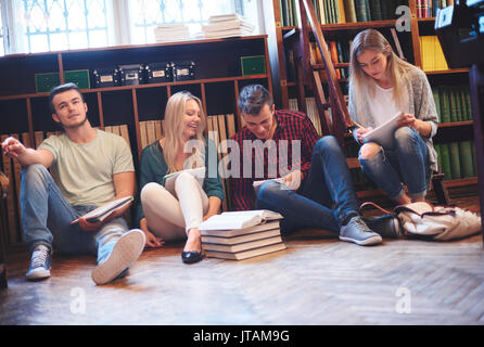 Students taking notes together in library Stock Photo