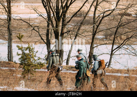 Rogachev, Belarus - February 25, 2017: Group Of Unidentified Re-enactors Dressed As German Wehrmacht Infantry Soldiers In World War II Marching Along  Stock Photo