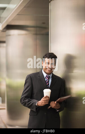 Indian business man with a tablet computer. Asian business man using digital tablet computer. Stock Photo