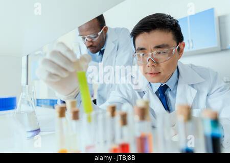 Professional scientists in white coats working together in chemical laboratory Stock Photo