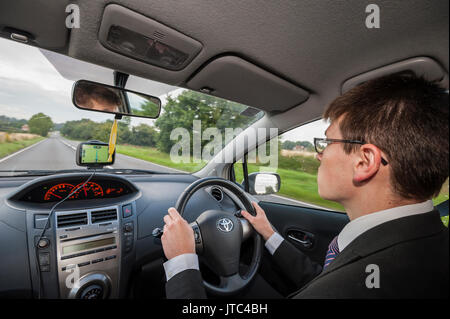 A model released teenage boy ,17 , driving on a main road in the Uk Stock Photo
