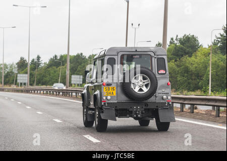 A Land Rover defender driving on a main road in the Uk Stock Photo