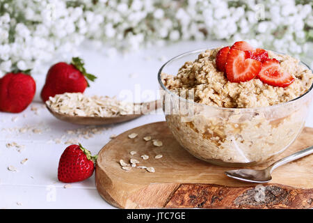 Hot breakfast of healthy oatmeal and heart shaped strawberries. Selective focus with extreme shallow depth of field. Stock Photo
