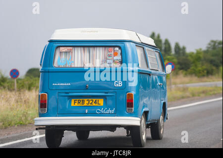 A classic VW campervan driving on a main road in the Uk Stock Photo