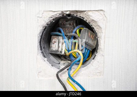 Electrician a wall socket with electronic multimeter Stock Photo
