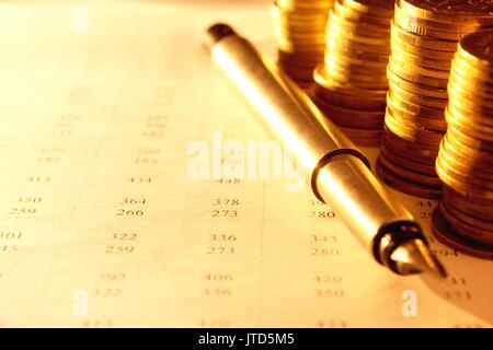 stacks of coins with numbers on documents Stock Photo