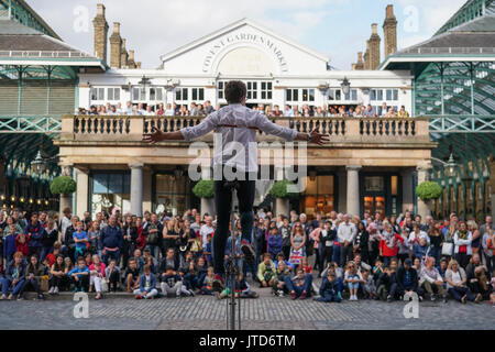 An escapologist unicyclist performing for crowds in Covent Garden in London. From a series of pictures of street performers in London, UK. Photo date: Stock Photo