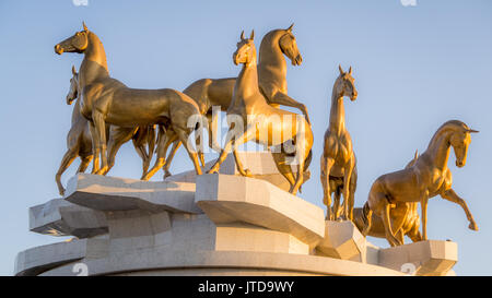 A monument of Akhal-Teke horses in Ashgabat, Turkmenistan. The horse breed is a Turkmen national emblem and is characterized by a metallic sheen. Stock Photo