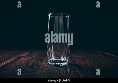 Close-up of an empty faceted glass on a black background, dark contrast light Stock Photo