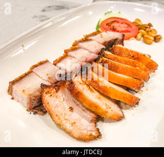 Crispy Pork and Char Siu Pork (Honey Roasted Pork) in the plate on table background. Stock Photo