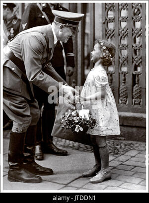 Adolf Hitler and child on a walk being presented with a flower basket by Helga Goebbels 1936. Helga was always said to be Hitler's favorite little girl. (subsequently poisoned by her mother in Hitlers Berlin bunker) Stock Photo