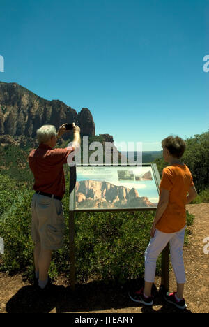 Caucasian Senior Couple (age 60-70) at Kolob Canyons at Zion National Park Springdale, Utah USA.. Caucasian male taking photo while female reads info. Stock Photo