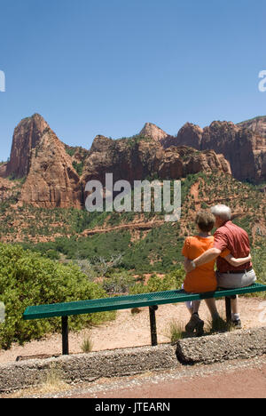 Caucasian Senior Couple (age 60-70) sitting on bench with arms around each other at Kolob Canyons at Zion National Park Springdale Utah USA. Stock Photo