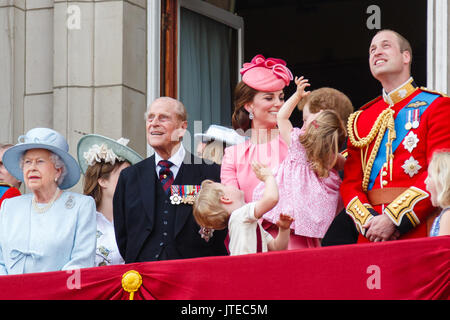 Prince George and Princess Charlotte, with the Duke and Duchess of Cambridge, look up excitedly on the balcony of Buckingham Palace during the flypast Stock Photo