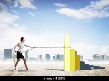 Businesswoman pulling arrow with rope and making it raise up Stock Photo