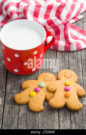 Two gingerbread men and mug of milk. Xmas gingerbread. Stock Photo