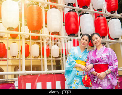 happy women wearing traditional kimono on travel in Japan, smiling happy standing front of colorful lantern and pose picture portrait outdoor during v Stock Photo