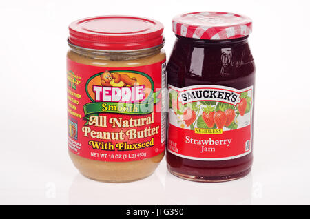 Unopened jars of Teddie's All Natural Peanut Butter w/ Flaxseed and Smuckers Strawberry Jam on white background. Stock Photo