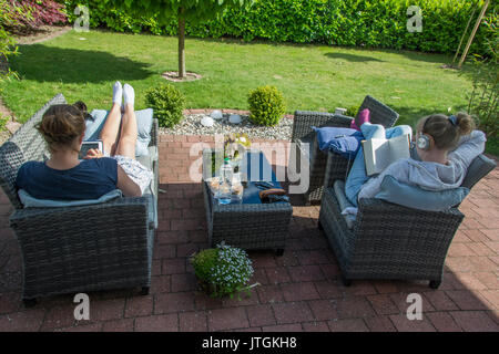 Two young German women relaxing at home in summer Stock Photo