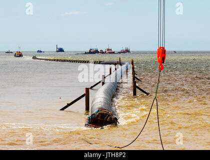 A new flood water outfall pipe has been transported by ship from Norway to the coast of Ireland and is now installed at Anchorsholme Beach, Blackpool, Lancashire. August 2017. This new extended submerged outfall pipe will discharge the excess screened stormwater out to sea and is part of improvements to the Fylde coast water management system. Filled with air to keep it afloat, the 20,000-tonne pipe left Ireland on Saturday afternoon and was pulled across the Irish Sea with an escort of 4 ships. Stock Photo