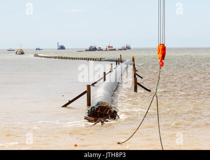 A new flood water outfall pipe has been transported by ship from Norway to the coast of Ireland and is now installed at Anchorsholme Beach, Blackpool, Lancashire. August 2017. This new extended submerged outfall pipe will discharge the excess screened stormwater out to sea and is part of improvements to the Fylde coast water management system. Filled with air to keep it afloat, the 20,000-tonne pipe left Ireland on Saturday afternoon and was pulled across the Irish Sea with an escort of 4 ships. Stock Photo