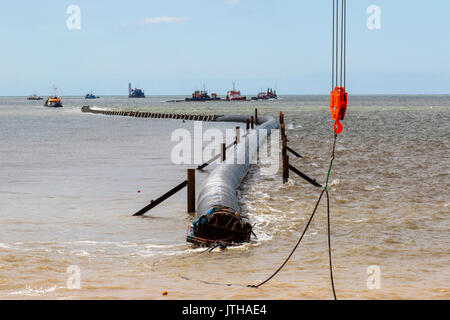 A new flood water outfall pipe has been transported by ship from Norway to the coast of Ireland and is now installed at Anchorsholme Beach, Blackpool, Lancashire. August 2017. This new extended submerged outfall pipe will discharge the excess screened stormwater out to sea and is part of improvements to the Fylde coast water management system. Filled with air to keep it afloat, the 20,000-tonne pipe left Ireland on Saturday afternoon and was pulled across the Irish Sea with an escort of 4 ships. Stock Photo