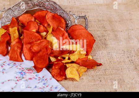 Plate of colorful organic vegetable chips with dip downward view on rustic wood Stock Photo