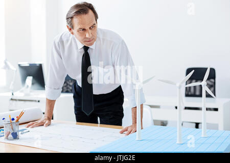 Senior engineer looking at windmill models Stock Photo