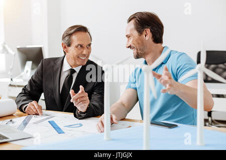 Two engineers working on a wind power station blueprint Stock Photo
