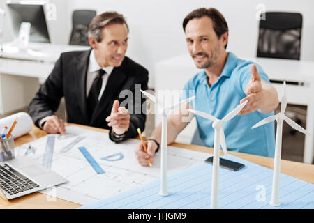 Two engineers pointing at the wind turbine models Stock Photo