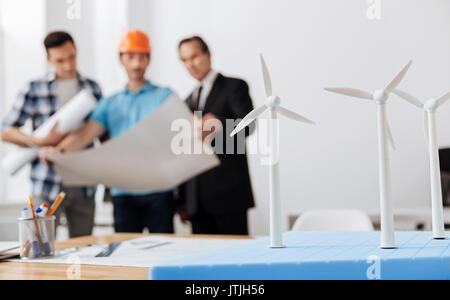 Three men discussing future wind power station project Stock Photo