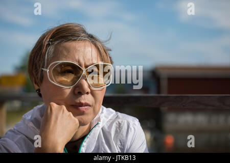 Beautiful mature Taiwanese Chinese woman listening during a conversation. Stock Photo