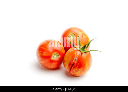Three juicy red zebra tomatoes, isolated on white background Stock Photo