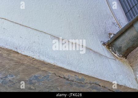 Small cracks in the plaster on the outer wall caused by a tree bend. Stock Photo