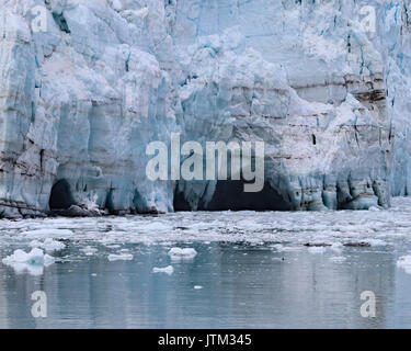 Small melt water caves along the bottom edge of Margerie Glacier in Glacier Bay National Park and Preserve, Alaska Stock Photo