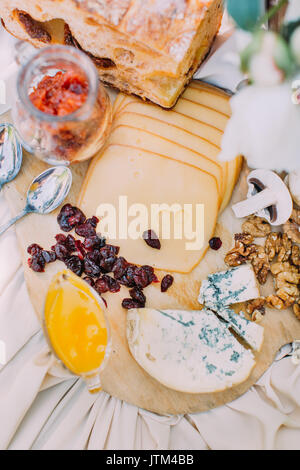Close-up tasty composition of the different types of cheese, prunes and walnuts placed on the wedding table(view above). Stock Photo