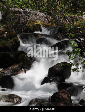 Small waterfall as river runs down mountainside Stock Photo