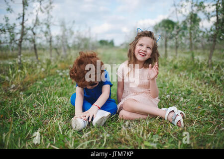 little boy and girl in blooming garden Stock Photo