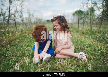 little boy and girl in blooming garden Stock Photo