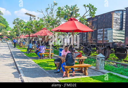 COLOMBO, SRI LANKA - DECEMBER 7, 2016:  The crowded outdoor cafe next to the freight train from the Fort Railway station, neighboring with Pettah Floa Stock Photo