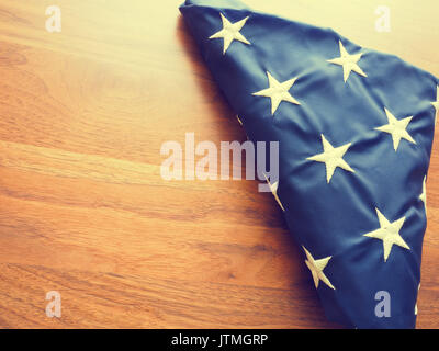 Folded American flag into a triangular shape on an old walnut office table with space for text or image Stock Photo