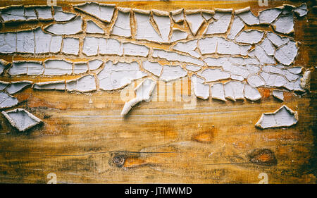 Old flaky white paint peeling off a grungy wooden board Stock Photo