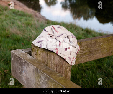 a bucket hat placed on a wooden post; UK Stock Photo