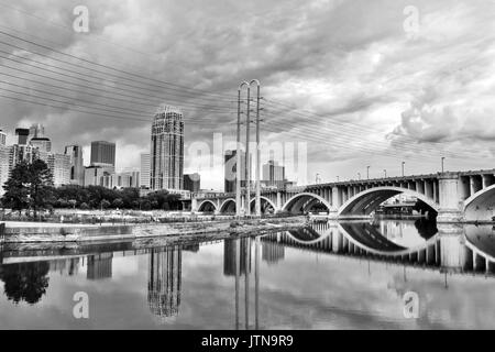 Minneapolis downtown skyline and Third Avenue Bridge above Mississippi river in black and white. Midwest USA, state of  Minnesota. Stock Photo