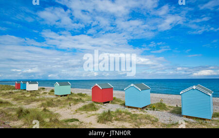 SEVEN PASTEL COLOURED BEACH HUTS ON THE SAND AND SHINGLE BEACH FINDHORN MORAY SCOTLAND Stock Photo