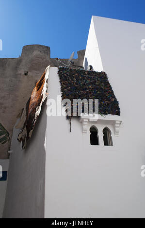 Morocco, Africa: carpets hanging from a terrace of a white house in Tangier, the moroccan city on the Maghreb coast with its unique blend of cultures Stock Photo