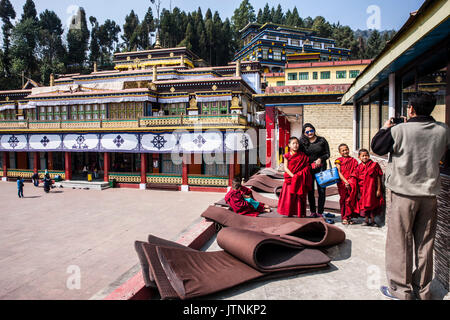 Visitors taking photos with Rumtek monks. Rumtek Monastery, also called the Dharmachakra Centre, founded by Wangchuk Dorje, 9th Karmapa Lama is a gompa located in the Indian state of Sikkim near the capital Gangtok. India. Stock Photo